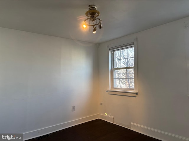 unfurnished room with dark wood-type flooring