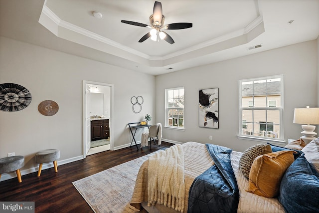 bedroom with a tray ceiling, ensuite bath, ceiling fan, and dark wood-type flooring