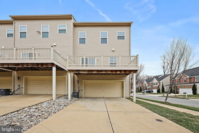 rear view of house with central AC unit and a garage