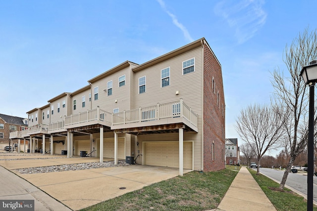 rear view of house with a garage, central AC unit, and a wooden deck