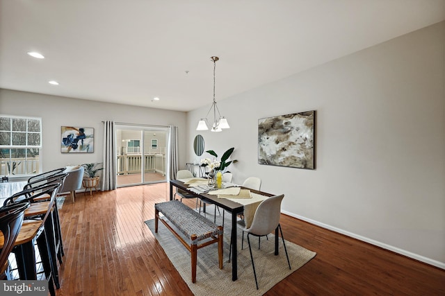 dining space with wood-type flooring and a notable chandelier