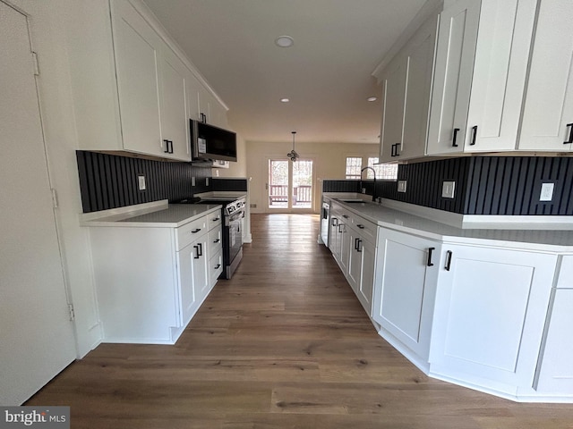 kitchen with sink, white cabinets, hardwood / wood-style floors, and appliances with stainless steel finishes