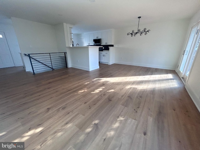 unfurnished living room featuring light hardwood / wood-style flooring and a notable chandelier