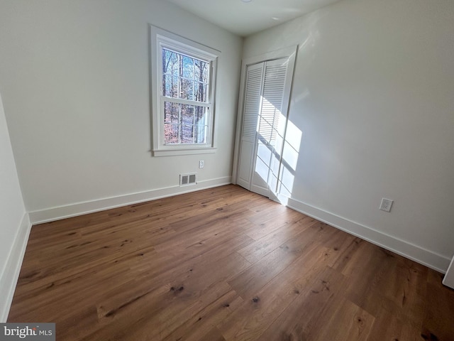 unfurnished room with wood-type flooring