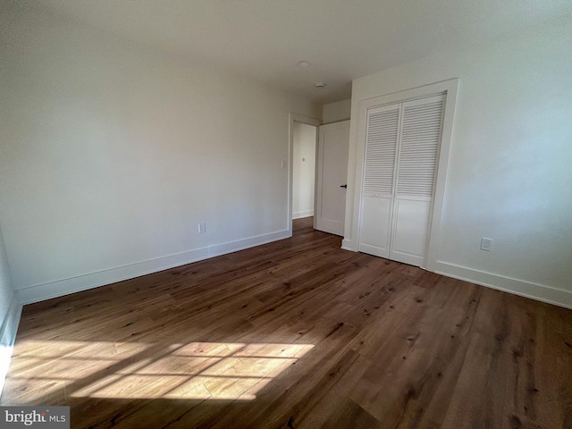 unfurnished bedroom with wood-type flooring and a closet