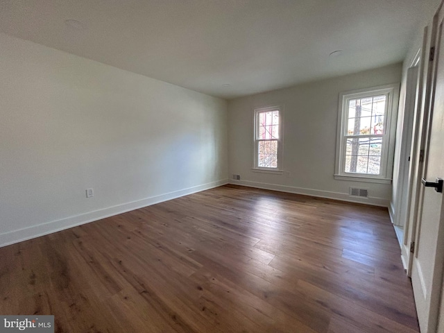 unfurnished room with dark wood-type flooring