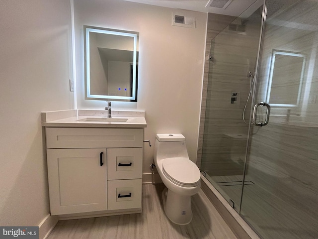 bathroom featuring vanity, hardwood / wood-style flooring, toilet, and walk in shower