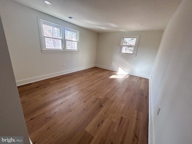 spare room with a healthy amount of sunlight and wood-type flooring