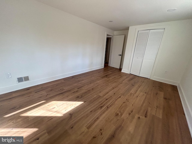 unfurnished bedroom with hardwood / wood-style flooring and a closet