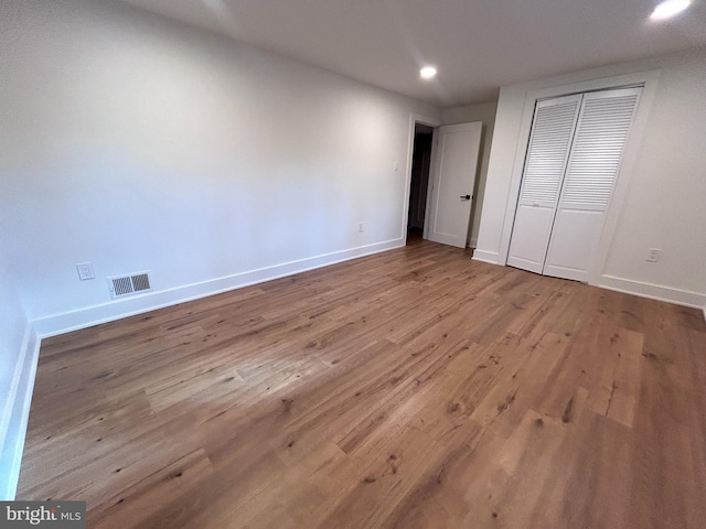 unfurnished bedroom with light wood-type flooring and a closet