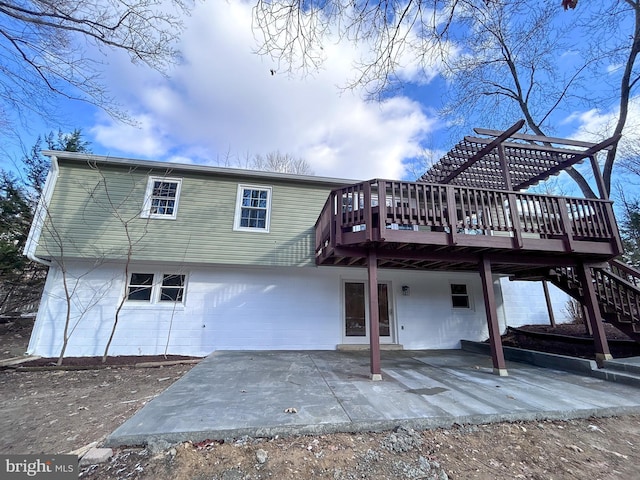 rear view of house with a patio and a wooden deck