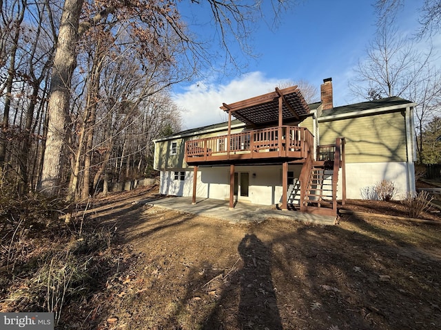 back of property with a pergola, a patio area, and a deck