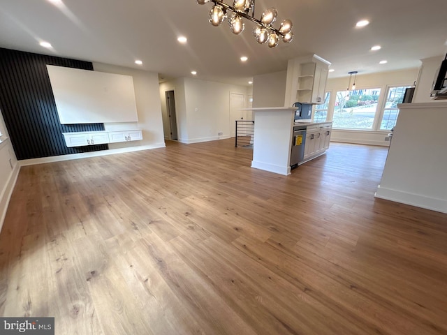 unfurnished living room with light hardwood / wood-style floors and an inviting chandelier