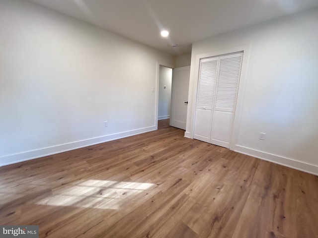 unfurnished bedroom featuring light hardwood / wood-style flooring and a closet