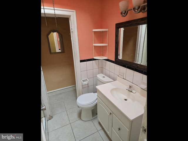 bathroom featuring vanity, toilet, tile patterned flooring, and tile walls