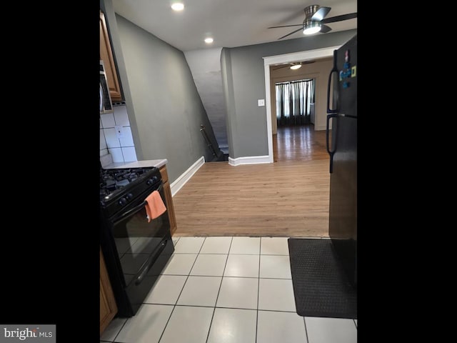 kitchen featuring black appliances, ceiling fan, and light wood-type flooring