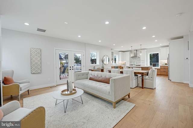 living area with visible vents, french doors, light wood-style flooring, and recessed lighting