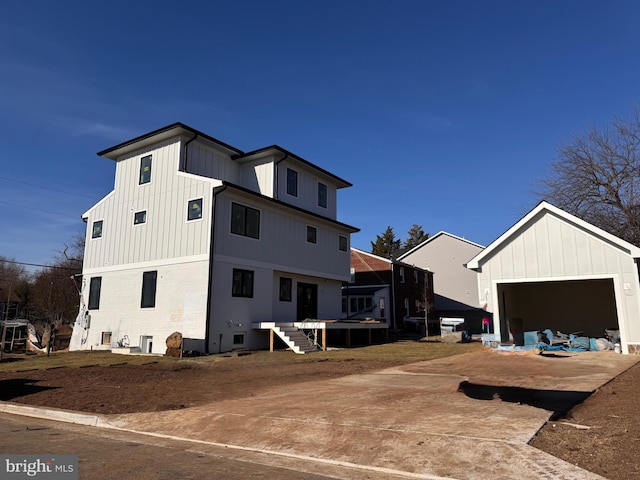 exterior space with a garage, board and batten siding, and an outbuilding