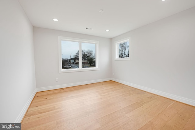 unfurnished room with recessed lighting, wood finished floors, visible vents, and baseboards