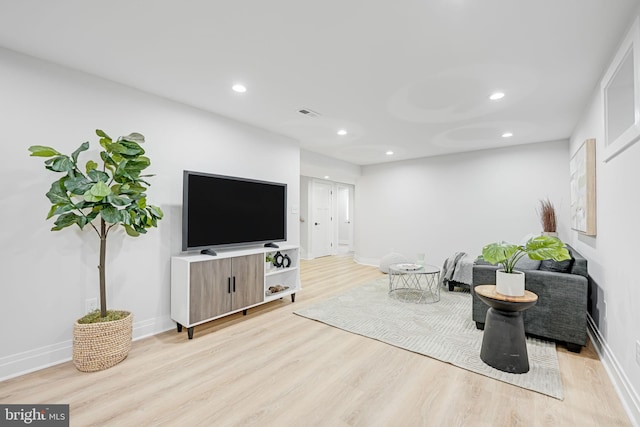 living room with light wood-type flooring, baseboards, and recessed lighting