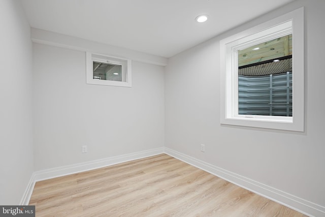 spare room with baseboards, wood finished floors, and recessed lighting