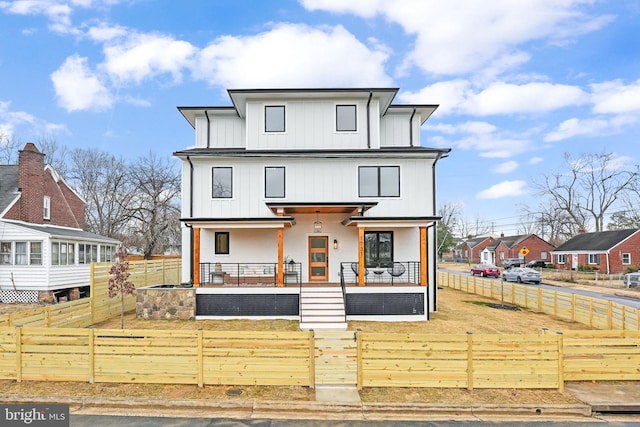 modern farmhouse featuring a fenced front yard, a porch, board and batten siding, a gate, and a residential view