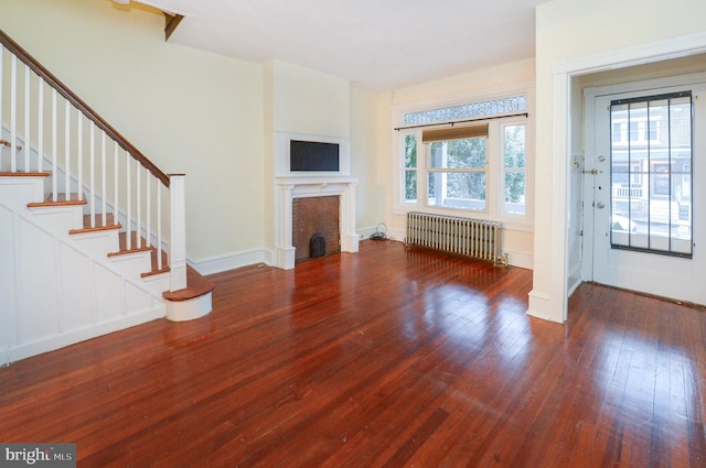 unfurnished living room with dark hardwood / wood-style flooring and radiator