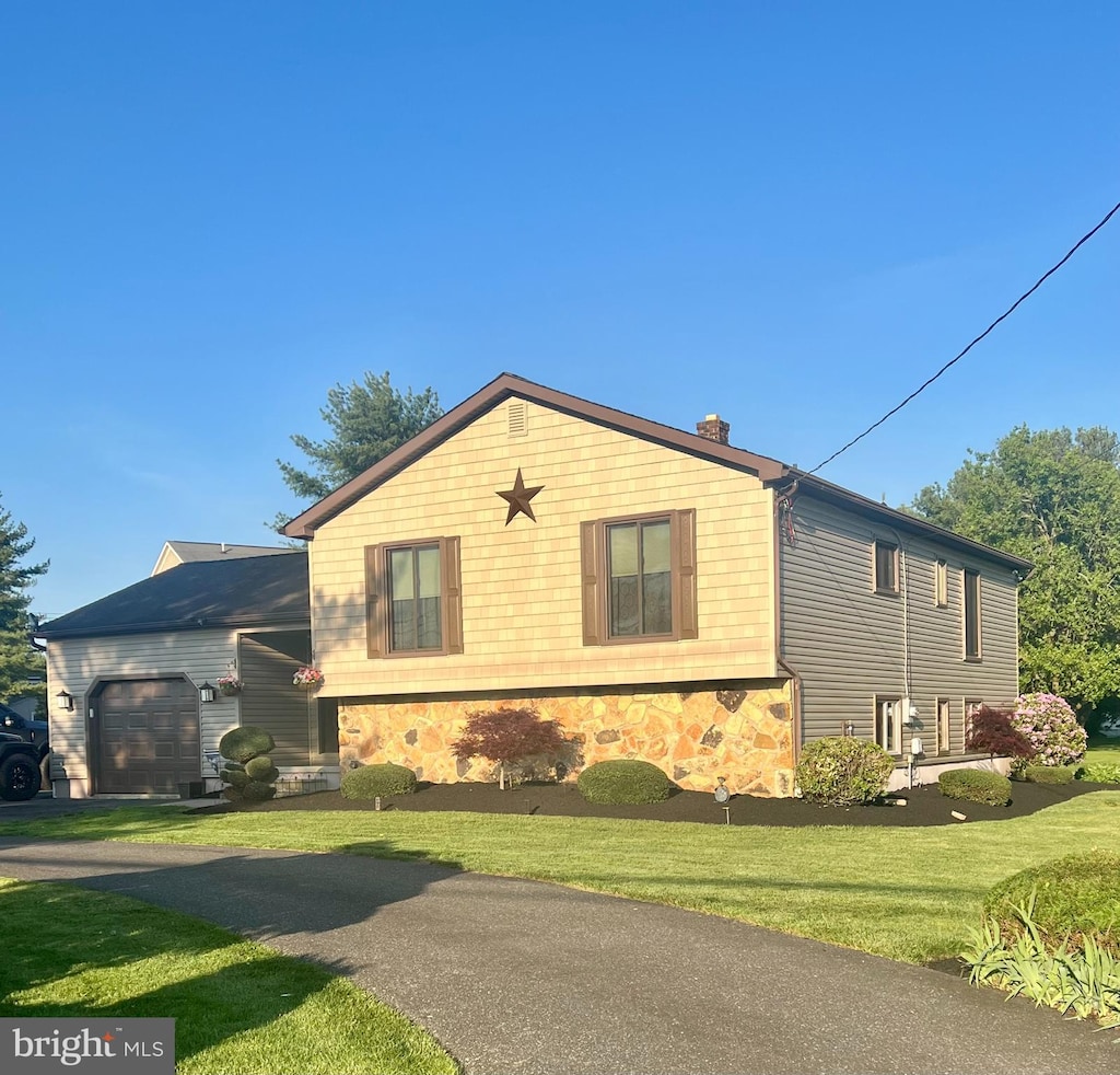 view of front of property with a front yard and a garage