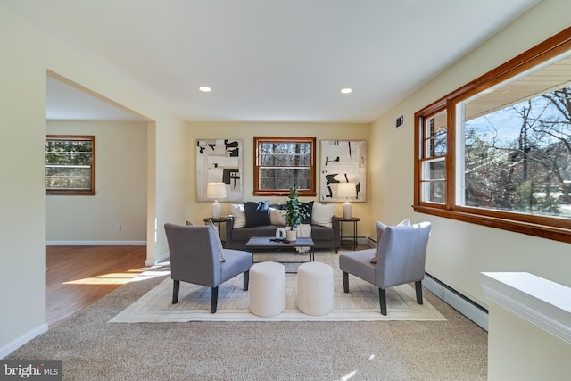 carpeted living room with baseboard heating