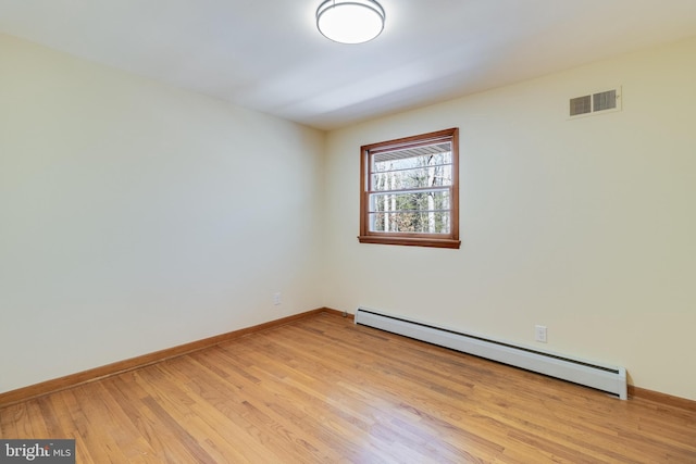 spare room with baseboard heating and light wood-type flooring