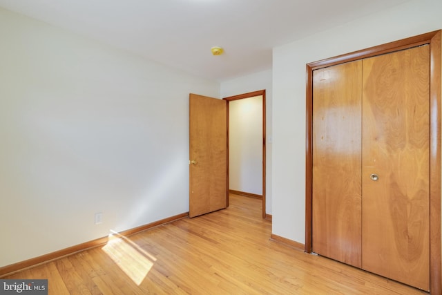 unfurnished bedroom featuring a closet and light wood-type flooring