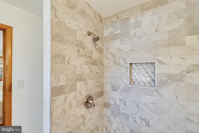 interior details featuring tiled shower