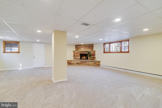 basement featuring carpet, a baseboard heating unit, and a fireplace