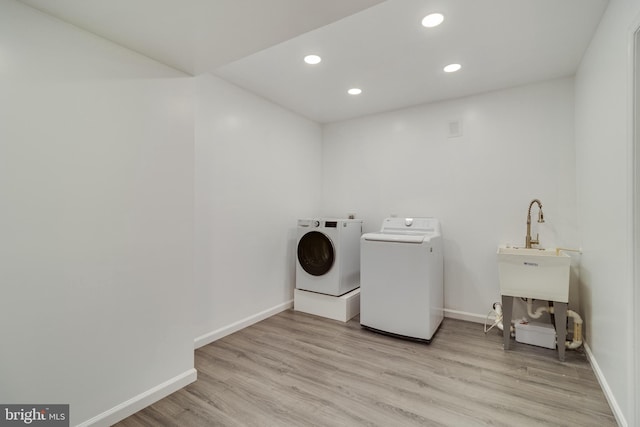 washroom featuring washing machine and dryer and light wood-type flooring