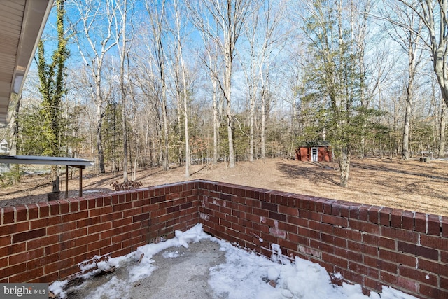 snow covered patio with a storage unit