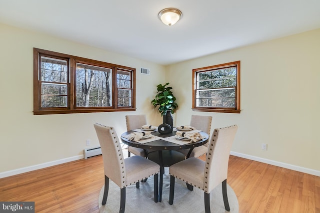 dining room with a baseboard radiator and light hardwood / wood-style floors