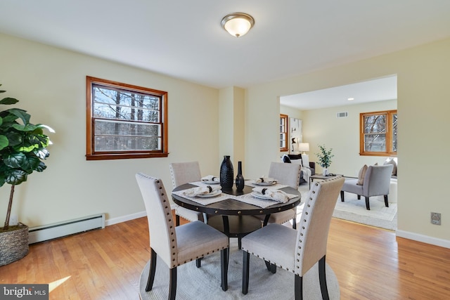 dining area with baseboard heating and light hardwood / wood-style flooring