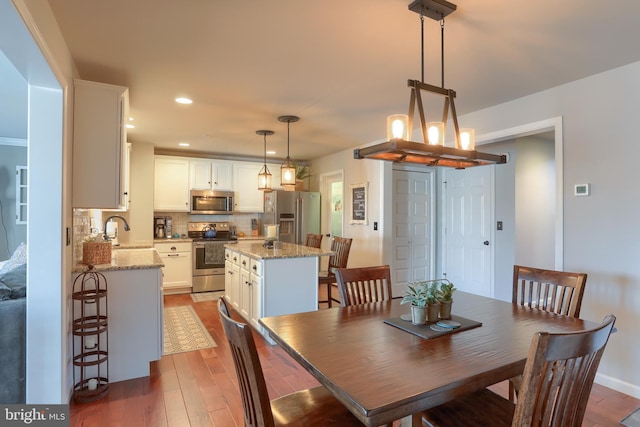 dining space with dark hardwood / wood-style floors and sink