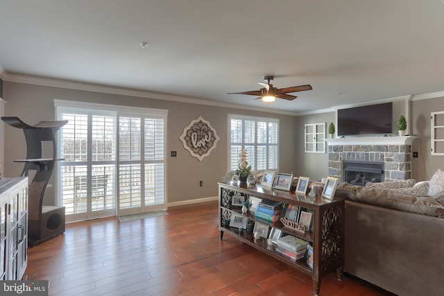 living room with a wealth of natural light, ceiling fan, a fireplace, and dark hardwood / wood-style floors