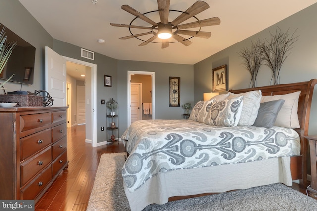 bedroom featuring connected bathroom, ceiling fan, and dark wood-type flooring