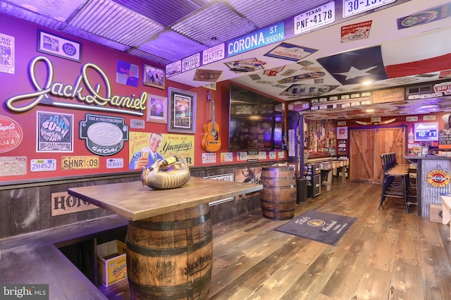 bar with wood walls and wood-type flooring