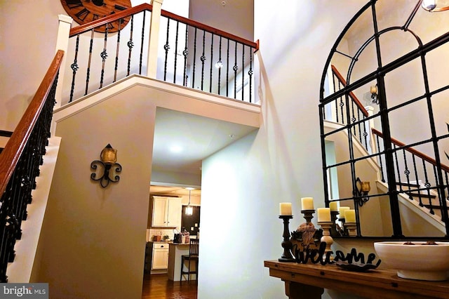 stairway featuring a towering ceiling