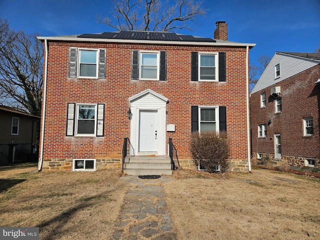 view of front of home featuring solar panels and a front yard