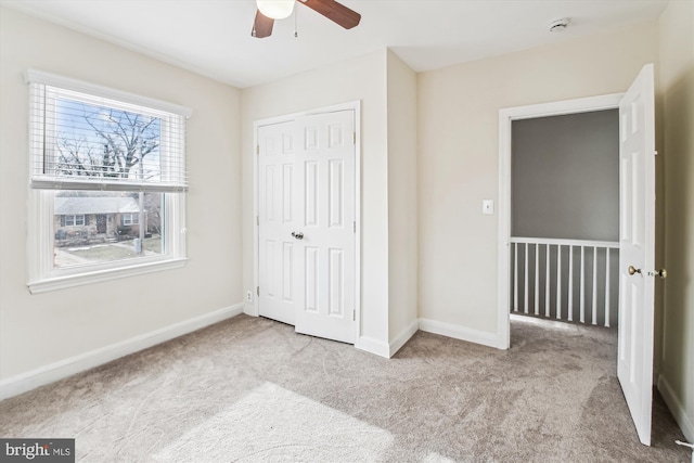 unfurnished bedroom with light carpet, a closet, and ceiling fan