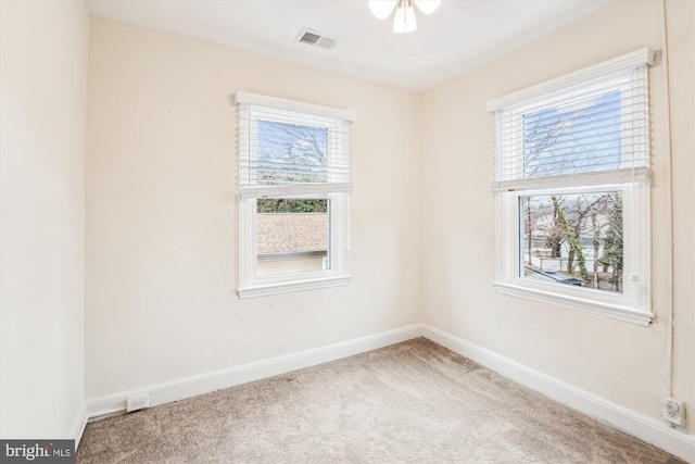 unfurnished room with ceiling fan, carpet flooring, and a wealth of natural light