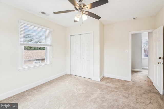 unfurnished bedroom with light carpet, ceiling fan, and a closet