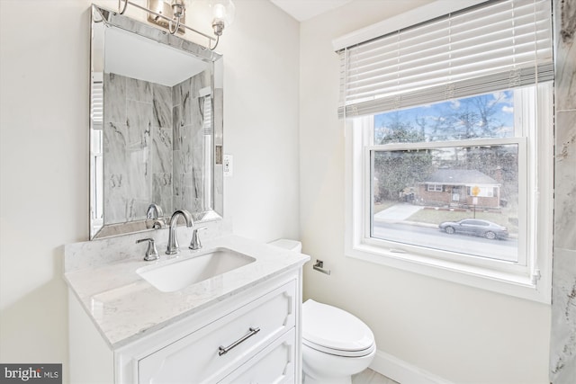 bathroom with vanity, toilet, and a shower