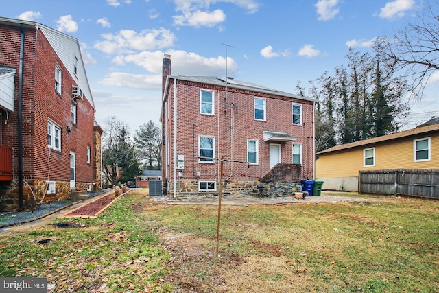 rear view of house featuring a yard and central AC