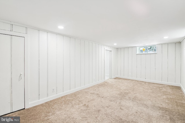 basement featuring light carpet