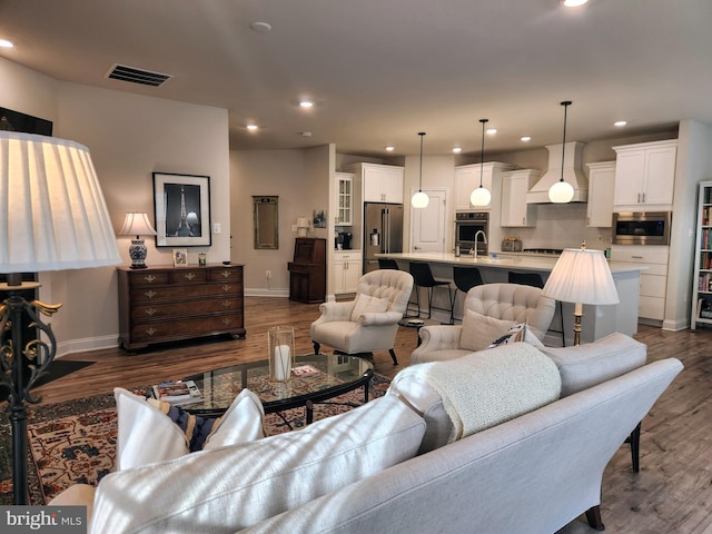 living room featuring dark wood-type flooring, recessed lighting, visible vents, and baseboards